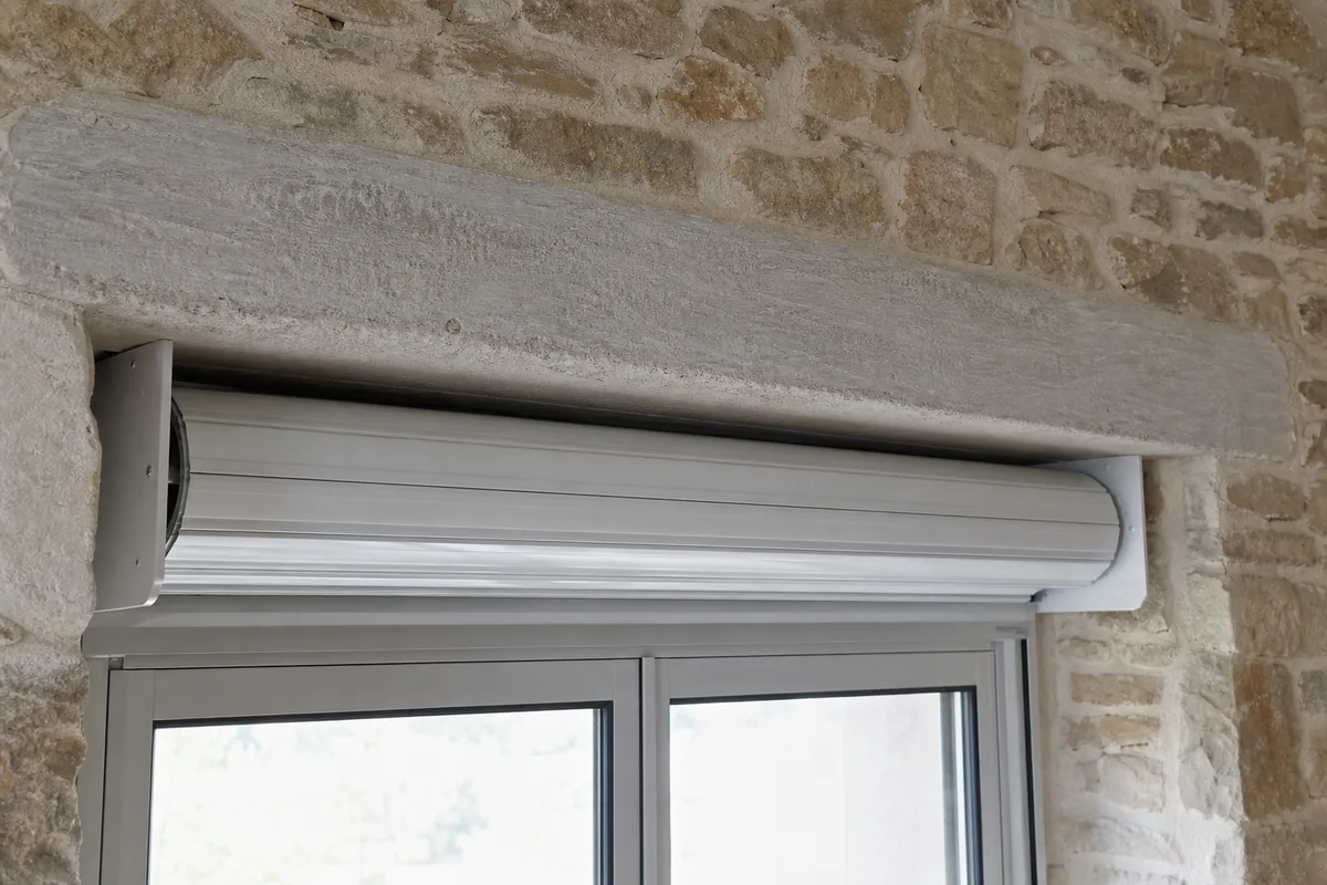 Volet roulant rénovation posé sous le linteau d&rsquo;une fenêtre en pierre